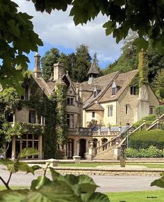 an old house with ivy growing on it's sides and stairs leading up to the front door