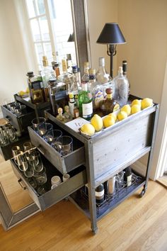 a bar cart filled with liquor bottles and lemons