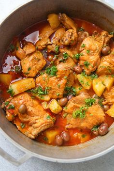 a pot filled with stew and vegetables on top of a table