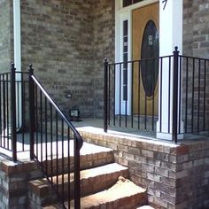 a set of stairs leading up to a front door with a black iron hand rail