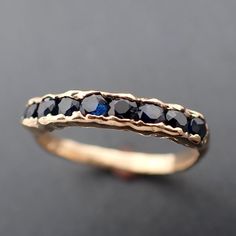 a gold ring with blue sapphire stones on it's sides, sitting on a black surface