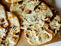 several flat breads on a cutting board with black pepper sprinkled on them