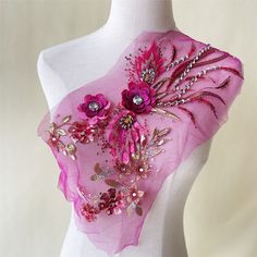 a pink scarf with flowers and pearls on it