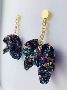 A bold, fun and colourful statement dangle earring featuring an oversized silk bow suspended from a gold plated rolo chain. Available in a variety of beautiful Liberty prints and also available as a regular size.  Each earring set is designed and handmade by myself in my Dartmoor Devon studio, UK Material 100% silk Liberty print bow Chain: Gold plated rolo chain  Available in 5 beautiful Liberty print options (Please see my other listings). Measurements Length (whole earring): Approx 9cm Bow Wid Liberty Print, Rolo Chain, Silk Ribbon, Jewelry Pouch, Just Giving, Jewelry Branding, Beautiful Bracelet, Devon, Silk Printing