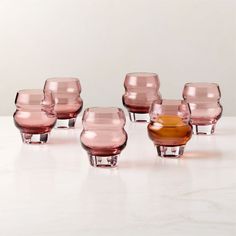 a group of pink glass cups sitting on top of a table next to each other