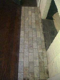 a bathroom with a toilet and tile flooring next to a door in the corner