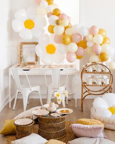 a room filled with lots of balloons and pillows on top of a wooden floor next to a table