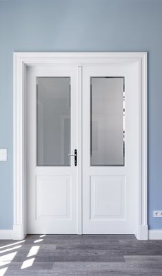 an empty room with two white doors and blue walls