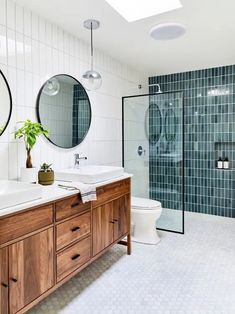 a bathroom with two round mirrors above the sinks