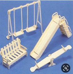 a set of miniature wooden toys including a swing, slide and bench with pegs