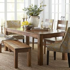 a dining room table with chairs and a bench