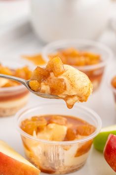 a spoon full of apple crispes with apples in the background