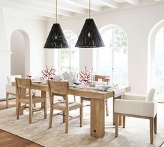 a dining room table and chairs in front of large windows