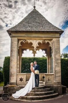 a bride and groom standing in front of a gazebo at the end of their wedding day