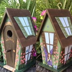 two wooden birdhouses with fairy paintings on them sitting in front of flowers and plants