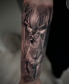 a man's arm with a deer tattoo on it