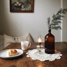 a wooden table topped with a plate of food next to a vase filled with flowers