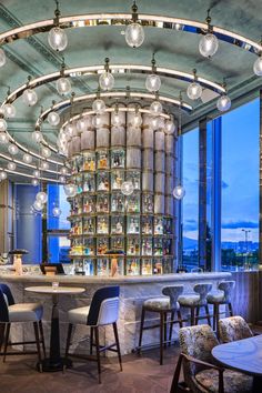 a bar with lots of lights hanging from the ceiling and chairs in front of it