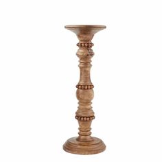 a tall wooden candle holder with beads on the top and bottom, sitting in front of a white background