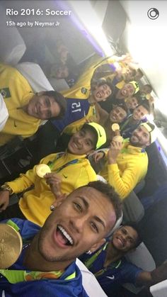 a group of people sitting next to each other on a bench with medals in their hands