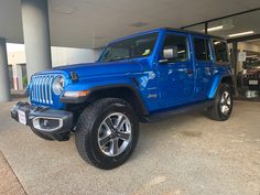 a blue jeep parked in front of a building