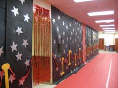 an empty hallway with red carpet and black curtained walls, decorated with white stars