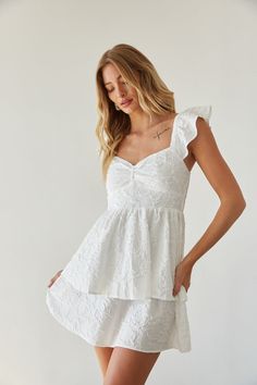 Get ready for sunny days in the Ashlyn Sweetheart Ruffle Fit and Flare Mini Dress! This white mini dress features a feminine sweetheart neckline, delicate flutter sleeves, and a flattering fit and flare silhouette. Unique with a floral texture and double tiered skirt, this white babydoll dress is ready to bloom! Accessorize to complete the look!Details 100% Polyester Elastic straps Smocked back panel Partially lined Hand wash cold/ hang dry