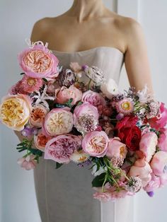 a woman holding a bouquet of flowers in her hands