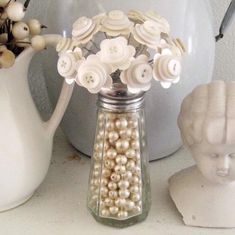 there is a vase with flowers and pearls in it