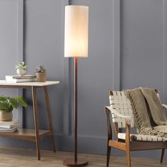 a living room scene with focus on the floor lamp and chair in the foreground