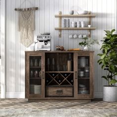 a wooden cabinet filled with lots of bottles and glasses next to a potted plant