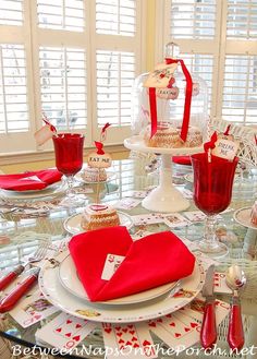 the table is set with red napkins and place settings