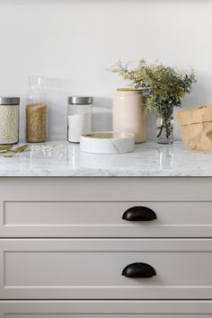 a white kitchen counter topped with lots of drawers