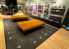 the inside of a shoe store with wooden flooring and display cases filled with shoes