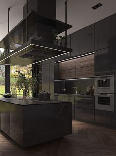 a modern kitchen with an island counter and stainless steel appliances in the center, surrounded by wood flooring