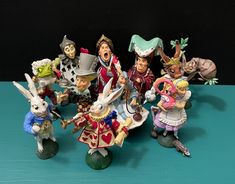 a group of figurines sitting next to each other on a blue table top