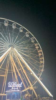 the ferris wheel is lit up at night