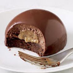 a piece of chocolate cake sitting on top of a white plate next to a fork