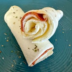 a wrap filled with meat and cheese on top of a blue plate