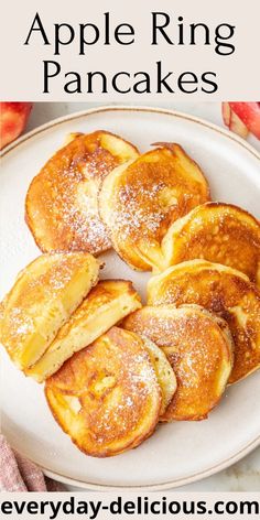 apple ring pancakes on a plate with powdered sugar