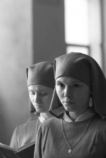 black and white photograph of two girls in nun costumes reading a book while standing next to each other