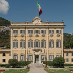 a large building with an italian flag on top of it's roof and windows