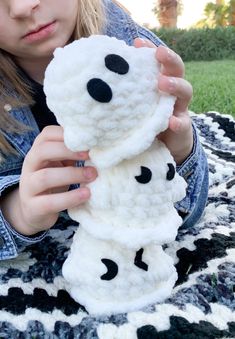 a girl is holding up a snowman made out of wool