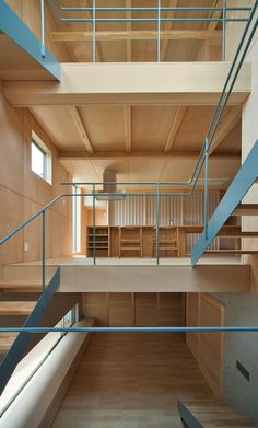 the inside of a building with wooden floors and blue railings on each side of the stairs