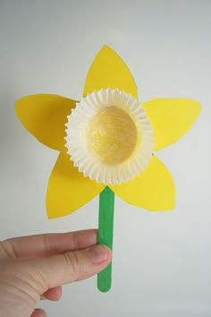 a paper flower being held up to show the size it is cut out and placed on top of