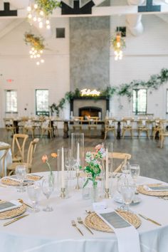 the tables are set up with place settings and flowers in vases on each table