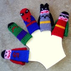 six knitted mittens arranged in a circle on the floor