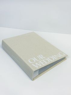 a white book with the words our wedding written on it's front and back cover