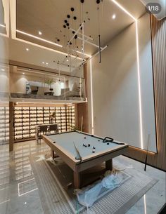 a pool table in the middle of a room with lots of lights hanging from the ceiling