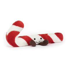 a red and white striped stuffed animal laying on top of it's back legs